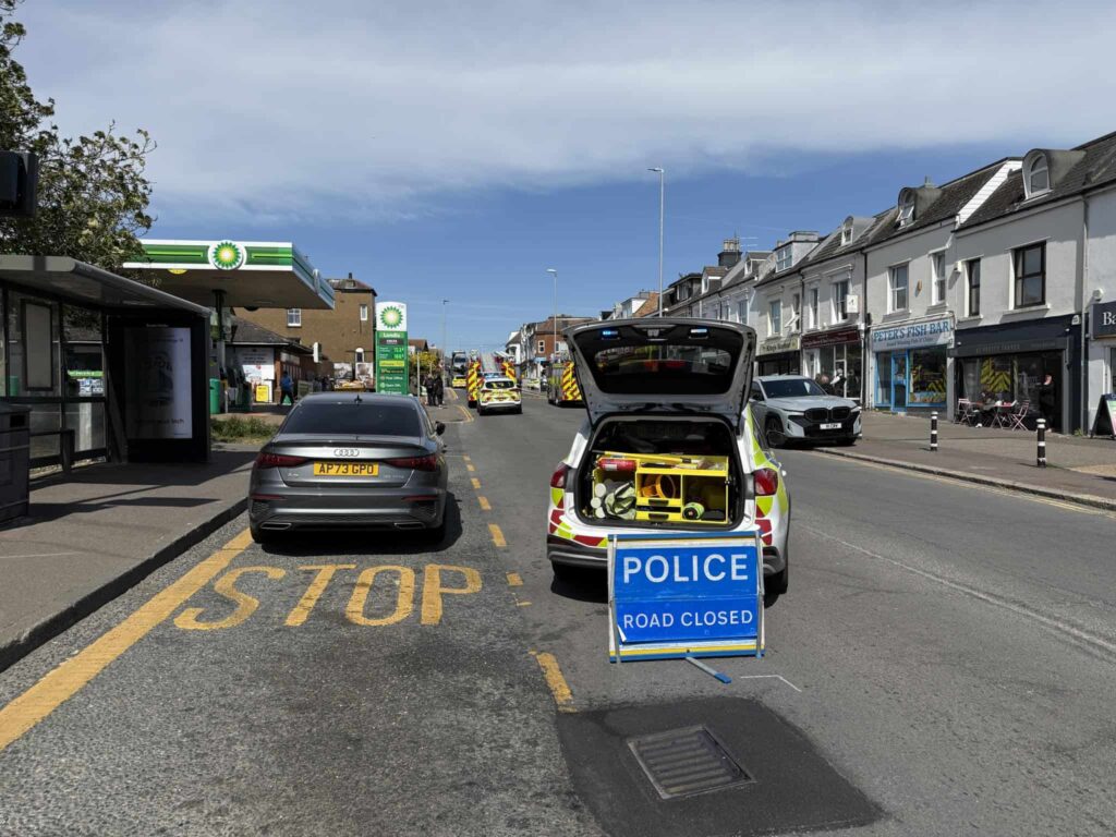 Emergency service vehicles at the scene with the road closed and cordons in place as police and fire crews respond to the incident.