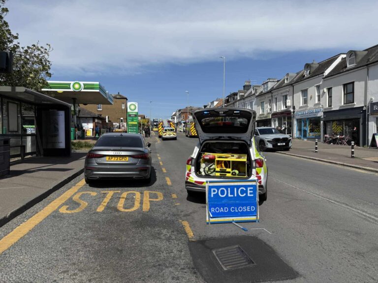 Emergency service vehicles at the scene with the road closed and cordons in place as police and fire crews respond to the incident.