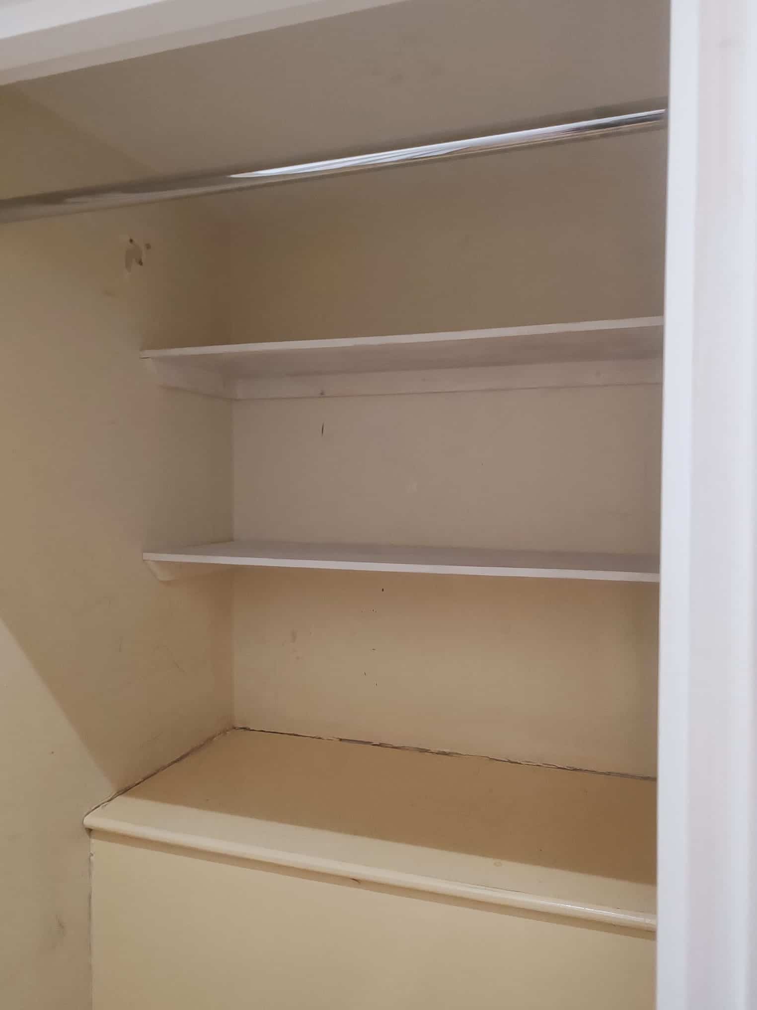 Custom fitted shelving installed inside a built-in storage cupboard beneath a staircase