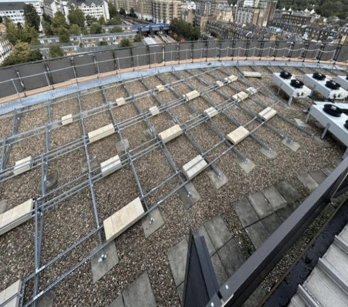 Metal mounting framework installed on a flat commercial rooftop ready for solar panel installation.