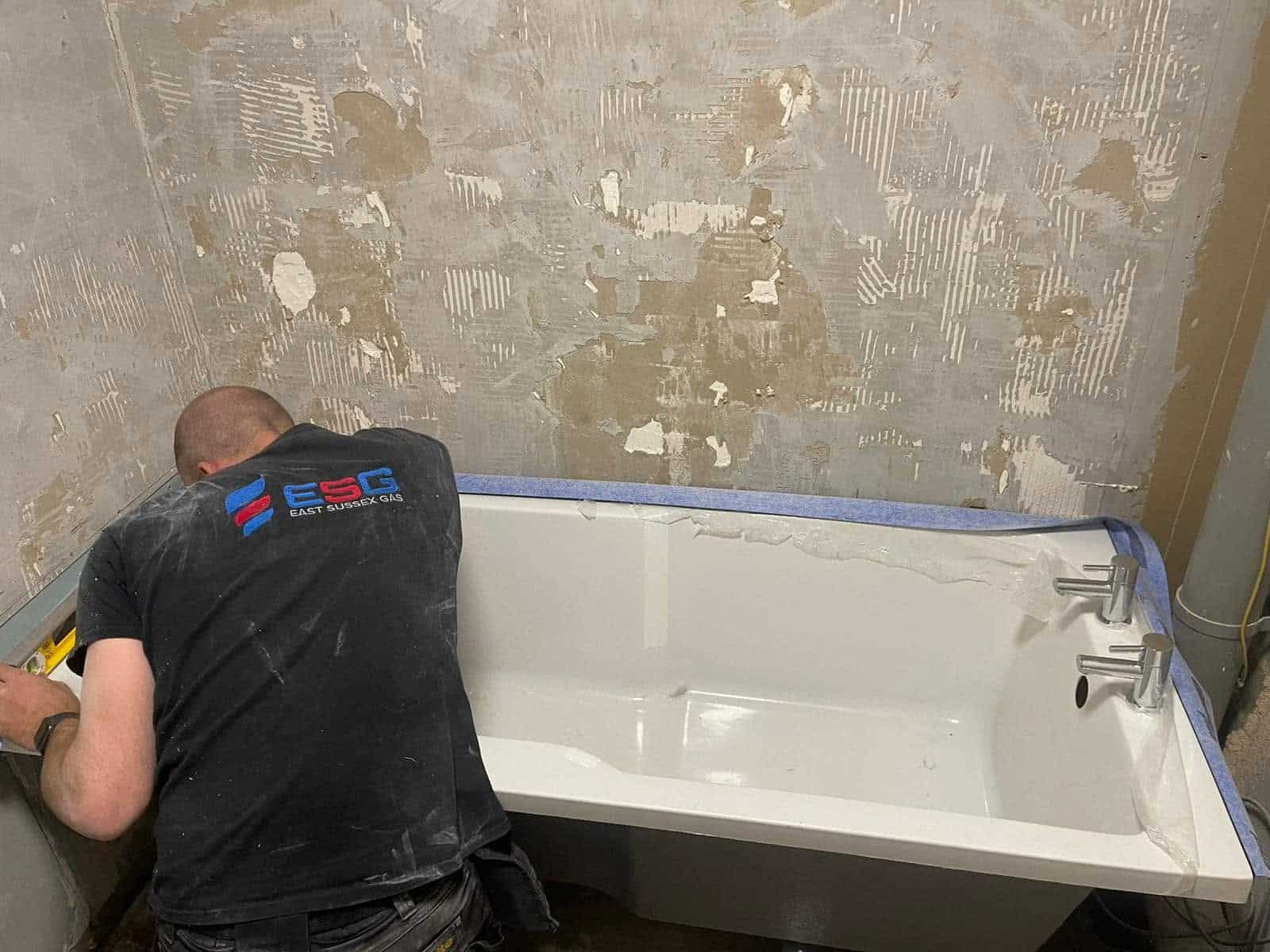 East Sussex Gas engineer fitting a new bath during a bathroom installation project