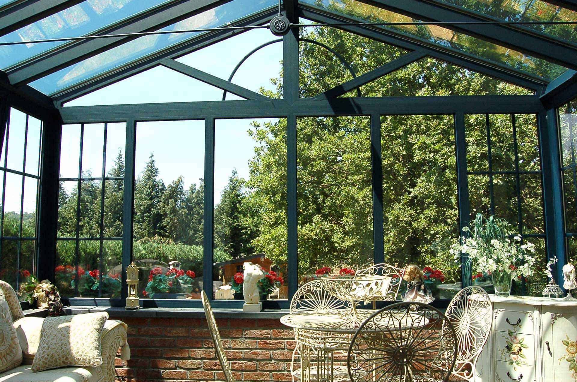 Bright conservatory with large glazed panels overlooking a mature garden