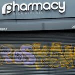 Graffiti sprayed across the metal security shutters of Pharmacy Requirements in Sidley following overnight vandalism.